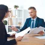 Business,Partners,With,Papers,Discussing,Work,At,Workplace,In,Office