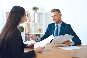Business,Partners,With,Papers,Discussing,Work,At,Workplace,In,Office