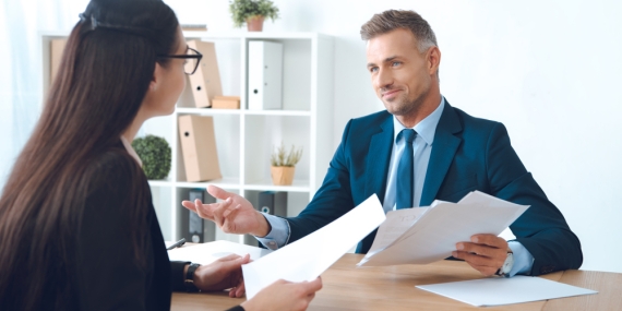 Business,Partners,With,Papers,Discussing,Work,At,Workplace,In,Office